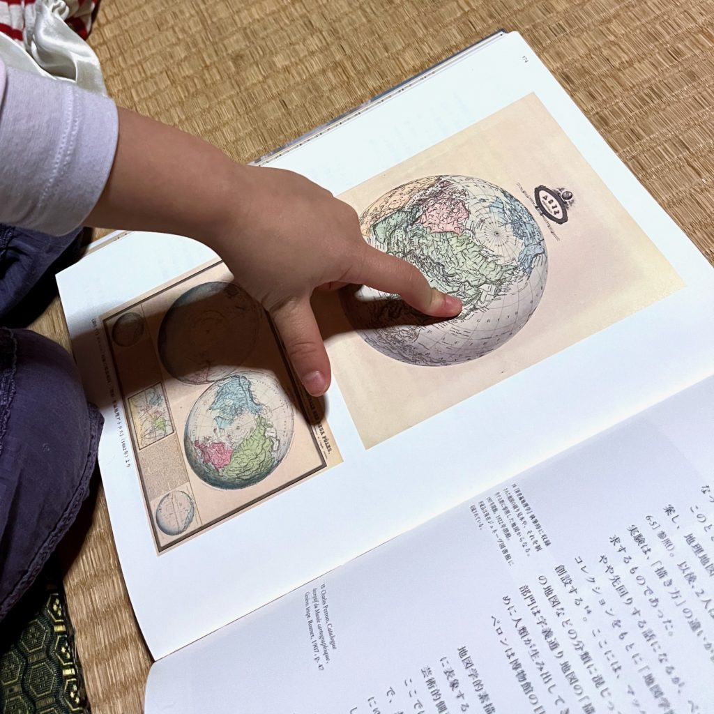小さな子供の手が地球儀の絵の日本を指している